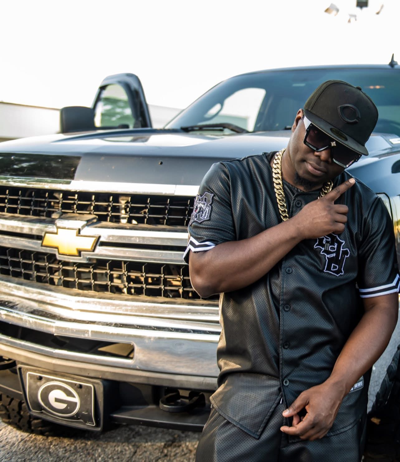 Tilt posing beside a black truck